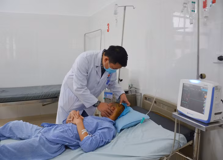 Bác sĩ CKI Lục Chiến Thắng, TTYT Tiên Yên kiểm tra tình trạng người bệnh sau mổ chấn thương sọ não.