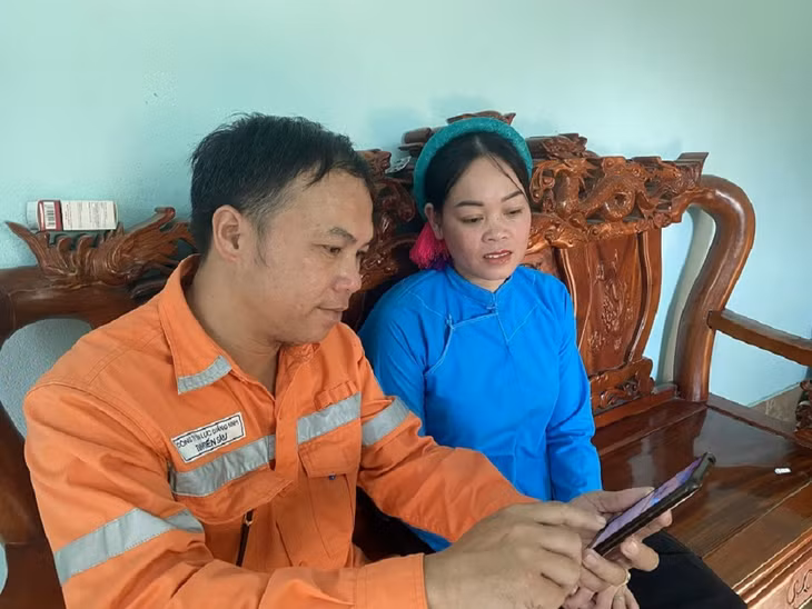 Công nhân Điện lực Bình Liêu hướng dẫn khách hàng sử dụng công cụ ước tính sản lượng.