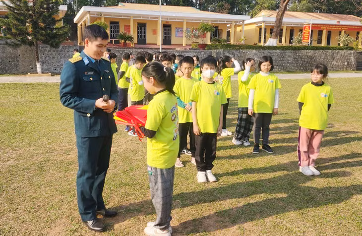 Học sinh lớp 6A Trường THCS Trọng điểm (TP Hạ Long) tặng cờ cho các chú bộ đội Tiểu đoàn 83 tại Quảng Yên.