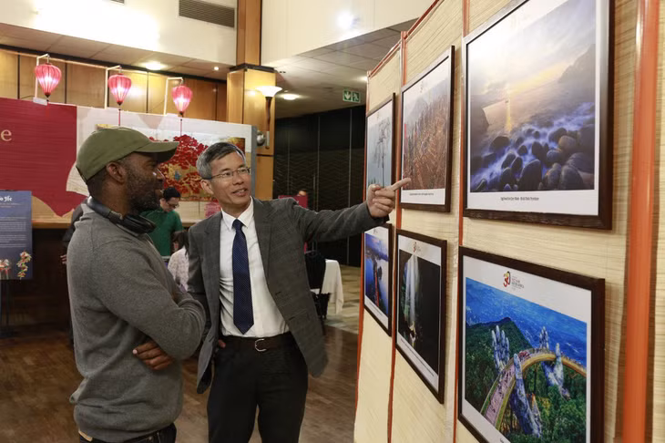 Ông Hoàng Hữu Anh - phó vụ trưởng Vụ Ngoại giao văn hóa và UNESCO - giới thiệu thông tin về triển lãm ảnh “Sức sống Việt Nam” đến khách tham quan - Ảnh: BTC