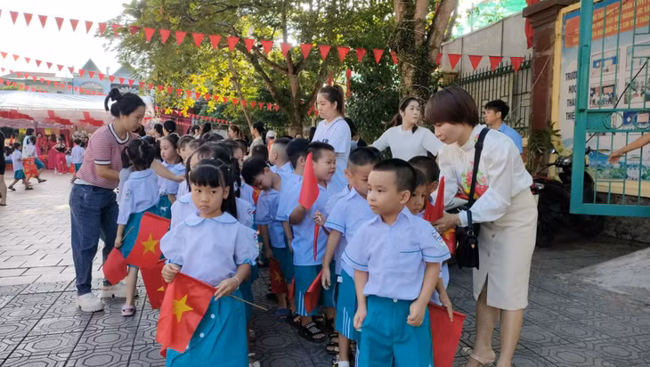 Các bậc phụ huynh sửa soạn quần áo, cờ hoa cho các bé lớp 1 lần đầu tiên cắp sách tới trường. Ảnh: Xuân Thao (CTV).
