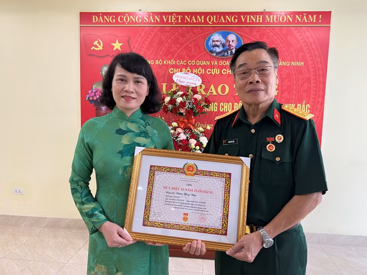 Đồng chí Nguyễn Thị Vinh, Tỉnh ủy viên, Bí thư Đảng ủy Khối các cơ quan và doanh nghiệp tỉnh, trao tặng Huy hiệu 45 năm tuổi Đảng cho đồng chí Đàm Huy Đắc, Chủ tịch Hội Cựu chiến binh tỉnh.