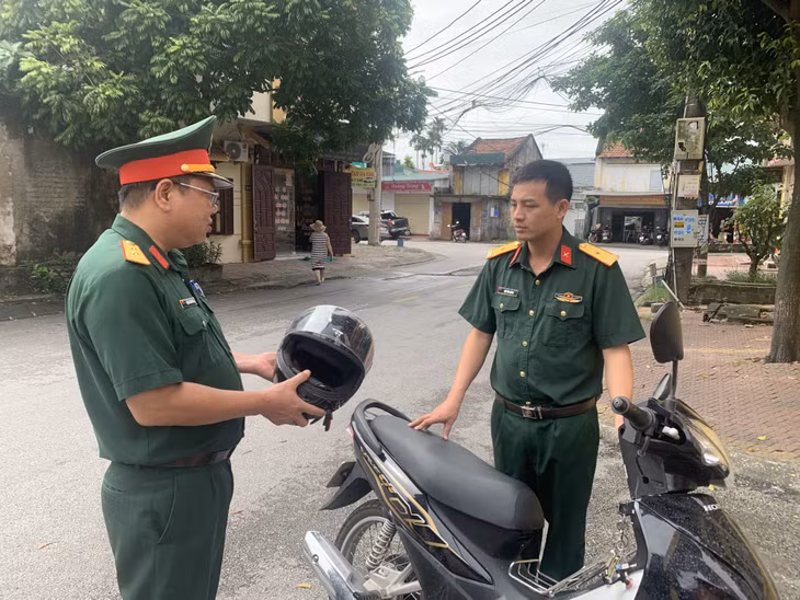 Cán bộ Ban Chỉ huy Quân sự TP Uông Bí nhắc nhở nhau khi tham gia giao thông phải đội MBH đạt chuẩn để đảm bảo ATGT.