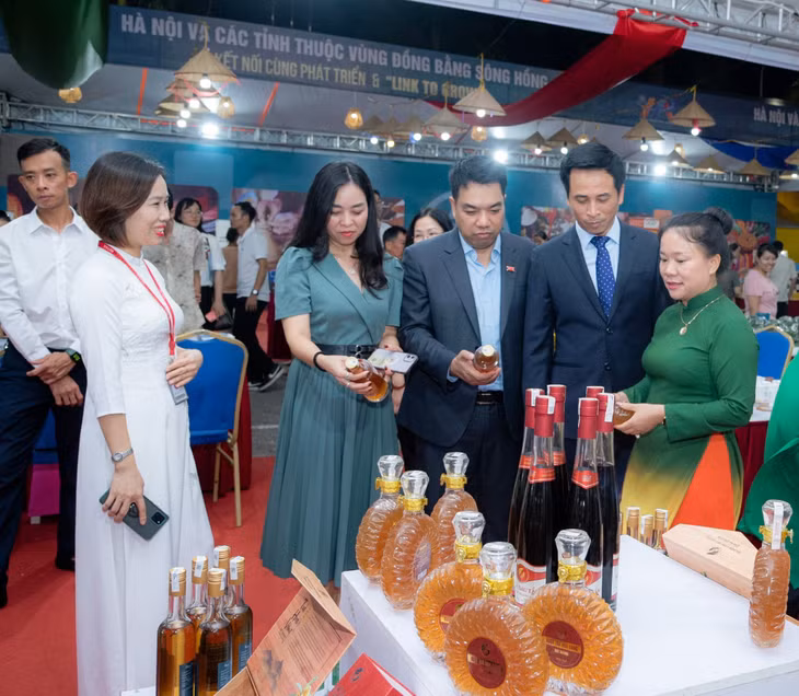 Bà Lê Thị Thêm, Chủ tịch HĐQT Công ty Cổ phần Đầu tư Hoàng Anh, HTX Sản xuất và Kinh doanh Huy Hoàng (ngoài cùng bên trái) tại không gian triển lãm quảng bá, giới thiệu về tiềm năng, cơ hội kết nối giữa Hà Nội và các tỉnh thuộc Vùng đồng bằng sông Hồng.