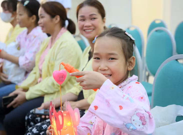 Các em nhỏ mừng vui, thích thú với món quà nhỏ là chiếc đèn Trung Thu.