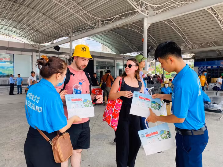 Cán bộ huyện Cô Tô tuyên truyền và cung cấp túi giấy thay thế túi nilon cho du khách. Ảnh do đơn vị cung cấp