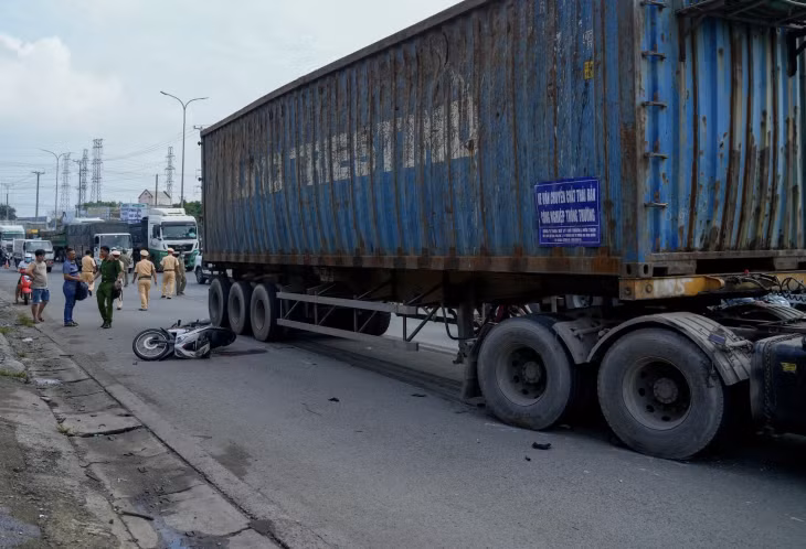 Xe máy đổ ra đường khiến nạn nhân ngã trúng bánh xe đầu kéo.