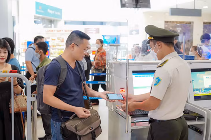 Hành khách qua cửa kiểm tra an ninh trước giờ lên máy bay.