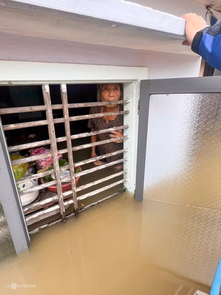 Bà Nguyễn Nhuân, 70 tuổi, đứng trong căn nhà ngập hơn một mét, nhìn ra ngoài cửa sổ khi lực lượng chức năng thị xã Đức Phổ đến hỗ trợ. "Mọi người trong gia đình đã qua nhà bên cạnh nhưng tôi nán lại để dời một số đồ lên cao", bà nói và cho biết sẽ chuyển sang nhà cao gần đó sớm nhất.