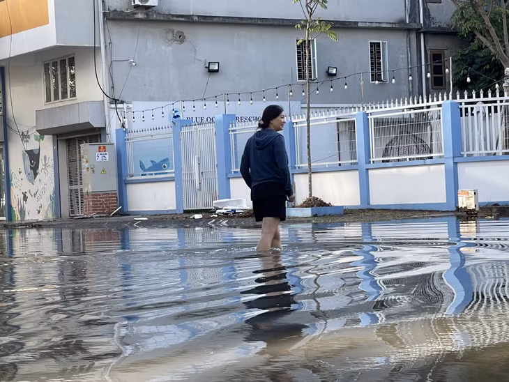 Nước ngập đến đầu gối làm ảnh hưởng đến việc đi lại và sinh hoạt của người dân.
