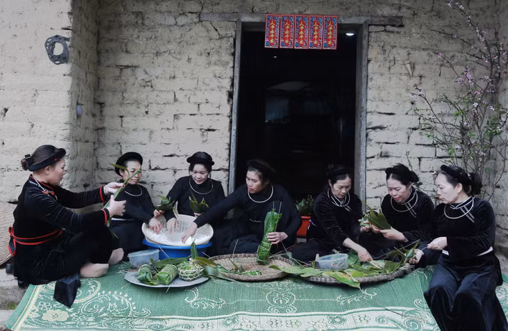 Phụ nữ người Tày huyện Bình Liêu quây quần cùng nhau gói bánh chưng đón Tết. Ảnh: Nguyễn Dung