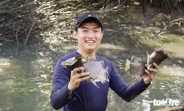 Du khách được hướng dẫn kỹ thuật bắt và cầm cá sao cho an toàn nhất