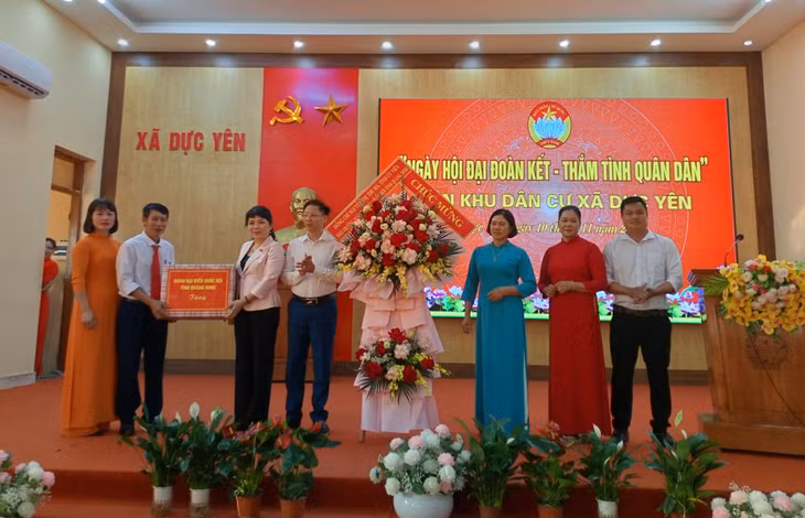 Đồng chí Nguyễn Thị Thu Hà, Phó Trưởng Đoàn ĐBQH tỉnh tặng quà chúc mừng Ngày hội đại đoàn kết xã Dực Yên.
