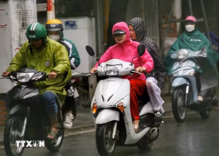 Người dân co ro trong mưa lạnh sáng 1/12. (Ảnh: Tuấn Đức/TTXVN)