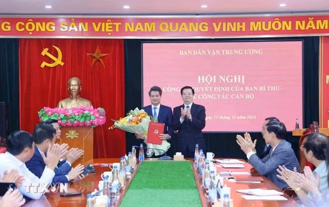 Ông Mai Văn Chính, Ủy viên Trung ương Đảng, Trưởng Ban Dân vận Trung ương, trao Quyết định của Ban Bí thư cho ông Nguyễn Quang Đức. (Ảnh: Phương Hoa/TTXVN)
