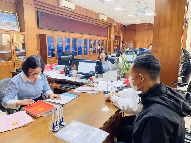 Cán bộ Trung tâm Hành chính công thành phố hướng dẫn người dân thực hiện các TTHC về đất đai.