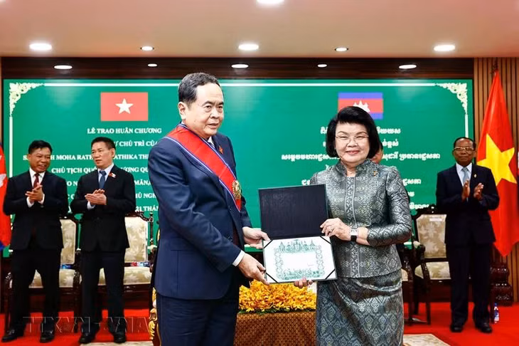 Chủ tịch Quốc hội Campuchia Samdech Khuon Sudary đeo dải băng, trao giấy chứng nhận Huân chương Đại Thập tự cho Chủ tịch Quốc hội Trần Thanh Mẫn. Ảnh: Doãn Tấn - TTXVN