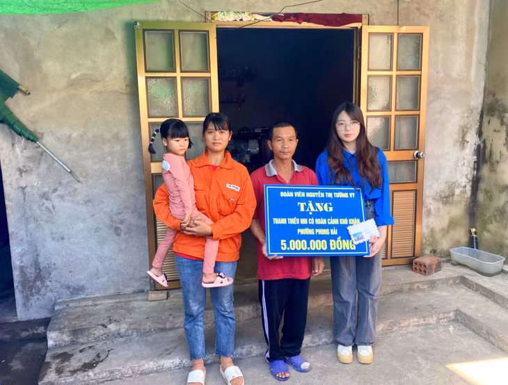 Đoàn viên Nguyễn Thị Tường Vy tặng quà đỡ đầu em Nguyễn Thế Trung có hoàn cảnh khó khăn tại phường Phong Hải. (Ảnh: Đoàn Thanh niên Cục thuế Quảng Ninh)