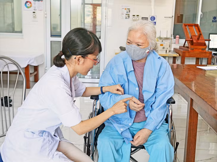 Tình nguyện viên Kamikawa Mariko trị liệu cho bệnh nhân tại Bệnh viện Lão khoa - Phục hồi chức năng tỉnh (Ảnh do đơn vị cung cấp).
