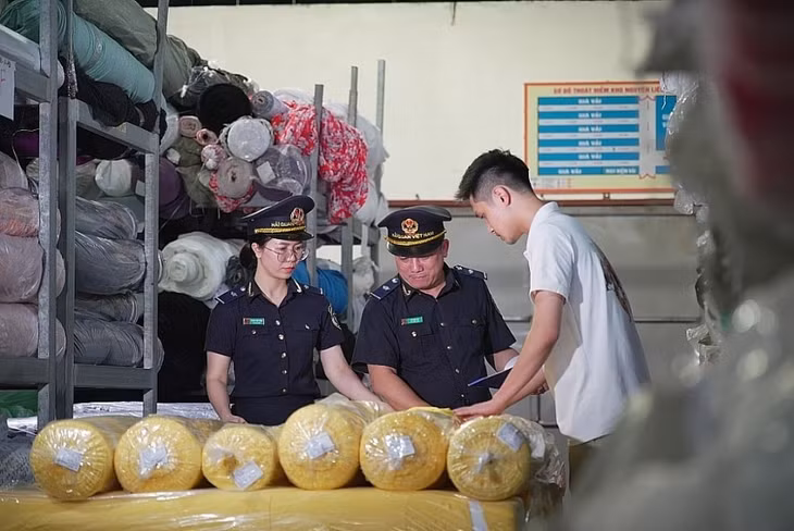 Công chức hải quan kiểm tra sau thông quan kho hàng vải nhập khẩu. Ảnh Văn Tá.