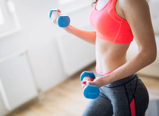 người phụ nữ khỏe mạnh tập luyện giảm mỡ bụng bằng tạ, khái niệm về bài tập tạ để giảm mỡ bụng