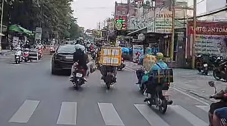 Nam thanh niên giơ chân đạp vào tay lái xe máy của người đàn ông - Ảnh: Cắt từ clip