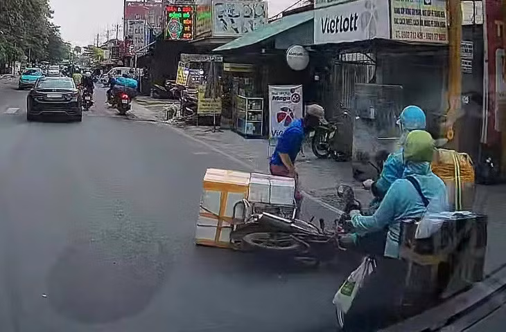 Người đàn ông ngã nhào xuống đường sau cú đạp vào tay lái xe máy của nam thanh niên - Ảnh: Cắt từ clip