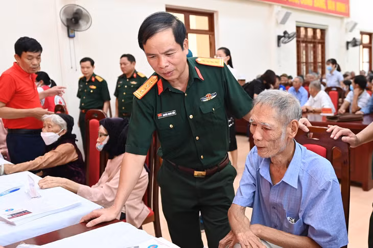 Đại tá Nguyễn Quang Hiến, Phó Bí thư Thường trực Đảng ủy, Chính ủy Bộ CHQS tỉnh, ân cần thăm hỏi sức khỏe các đối tượng chính sách tại buổi khám bệnh, cấp phát thuốc miễn phí cho người dân TX Quảng Yên.