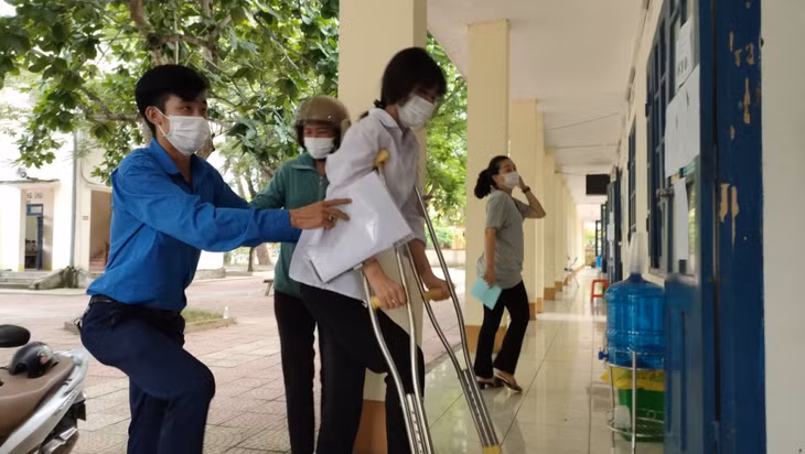 Thanh niên tình nguyện huyện Tiên Yên hỗ trợ người nhà đưa thí sinh khuyết tật tới điểm thi. Ảnh: Xuân Thao (CTV)