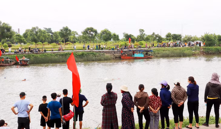 Trên bờ, khán giả, người thân đội nắng xem, cổ vũ cho các VĐV thi đấu.
