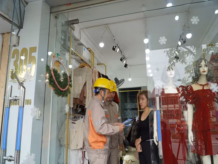 Công nhân Điện lực TP Hạ Long phát cẩm nang tuyên truyền An toàn điện trong nhân dân.