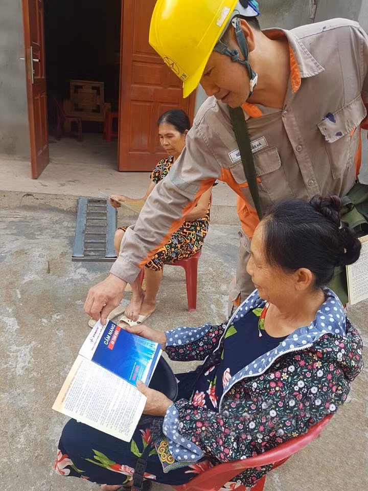 Công nhân Đội Quản lý vận hành lưới điện cao thế Quảng Ninh phát cẩm nang An toàn điện cho người dân.