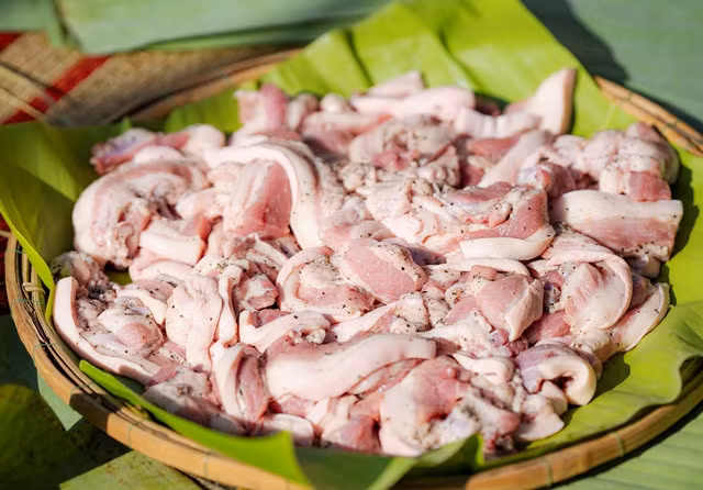 Thịt lợn được thái miếng dài, ướp đều với tiêu, hành, muối - Ảnh: VGP/Lê Hoàng