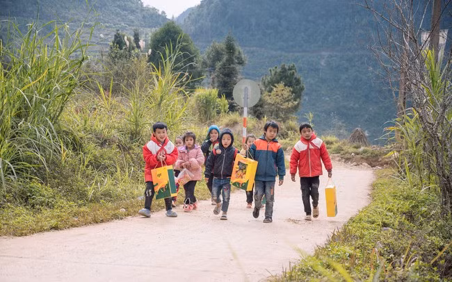Các em học sinh Trường phổ thông dân tộc bán trú Tà Lủng (Mèo Vạc, Hà Giang) tung tăng về nhà với phần quà Tết. Ảnh minh hoạ.