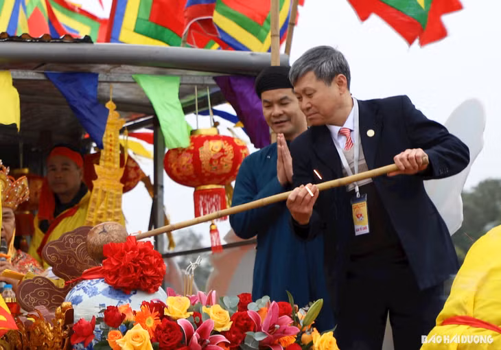 Dưới thuyền rồng, lãnh đạo Uỷ ban MTTQ tỉnh Hải Dương múc nước từ vòng sinh khí vào bình thuỷ