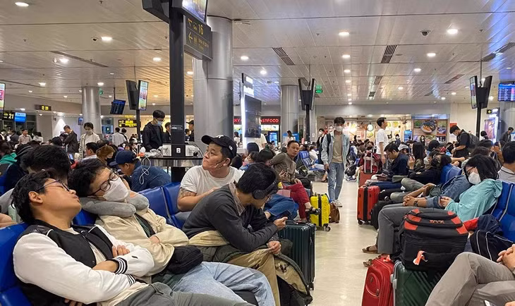 Hành khách vật vờ chờ ra tàu bay. Ảnh: Thùy Dung