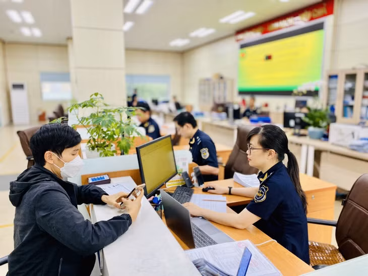 Công chức Chi cục Hải quan Cửa khẩu Móng Cái hướng dẫn doanh nghiệp thực hiện các thủ tục thông quan hàng hóa. Ảnh: Hoàng Nga