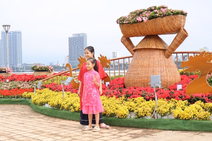 Các em bé thích thú chụp hình tại cụm trang trí “vũ điệu Xuân”.