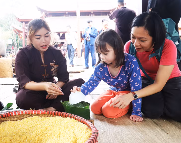 Nhiều du khách đã đưa trẻ nhỏ đến để trải nghiệm gói bánh chưng trong chương trình.