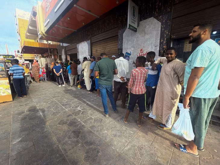 Một số người xếp hàng để nhận bánh mỳ ở Khartoum hôm 18/4. Ảnh: Reuters.