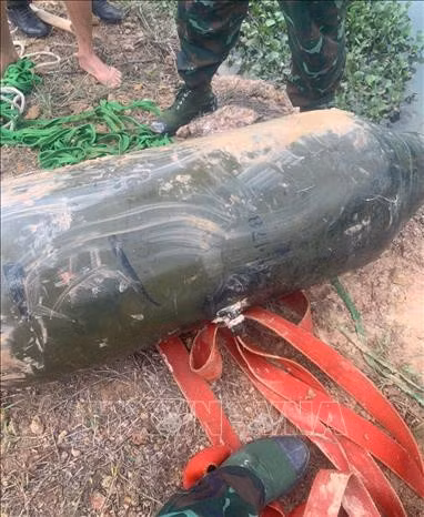 Lực lượng chức năng di dời, thu gom quả bom nặng 300kg dưới hồ nước sâu. Ảnh: TTXVN phát