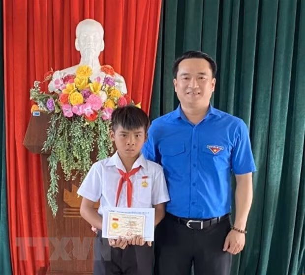 Hoc sinh lop 4 cuu 2 nguoi duoi nuoc nhan Huy hieu Tuoi tre dung cam hinh anh 1