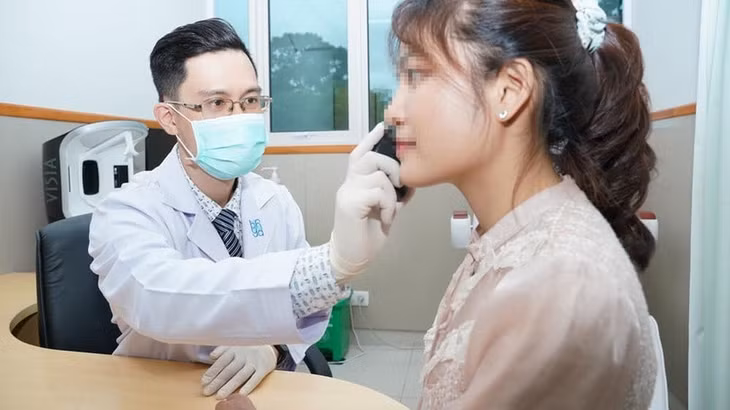 Bác sĩ Tạ Quốc Hưng, khoa Da liễu - Thẩm mỹ Da, Bệnh viện Đại học Y Dược TP.HCM, thăm khám cho bệnh nhân. Ảnh: BVCC.