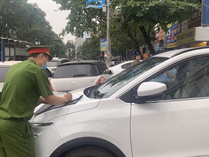 Công an phường Bạch Đằng (TP Hạ Long) lập biên bản xử lý trường hợp lái xe dừng, đỗ không đúng nơi quy định.