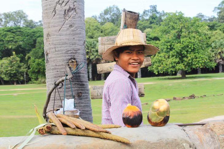 Một người Campuchia đang bán nước thốt nốt tươi trong quần thể Angkor - Ảnh: MINH HUYỀN