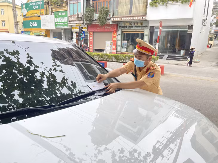 Lực lượng CSGT Công an TX Quảng Yên dán thông báo phạt "nguội" đối với chủ phương tiện vắng mặt khi dừng, đỗ sai quy định.