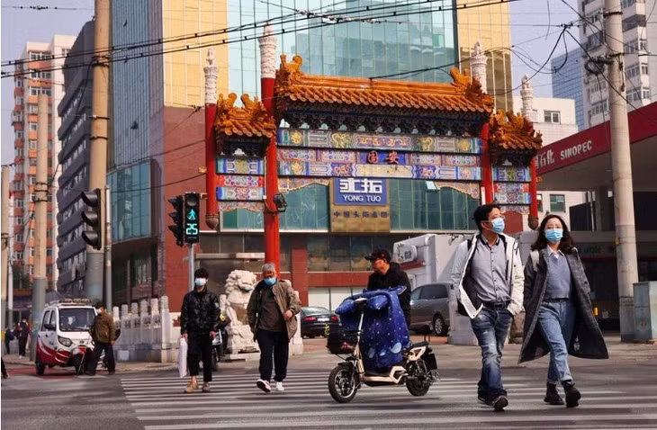 Người dân đi bộ trên một con phố ở Bắc Kinh. Ảnh: Reuters