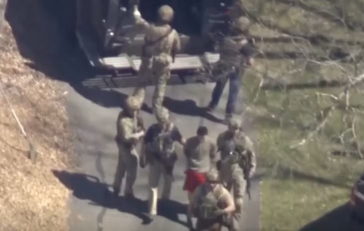 Nghi can Teixeira bị các đặc vụ FBI dẫn giải. Ảnh cắt từ clip của Reuters.