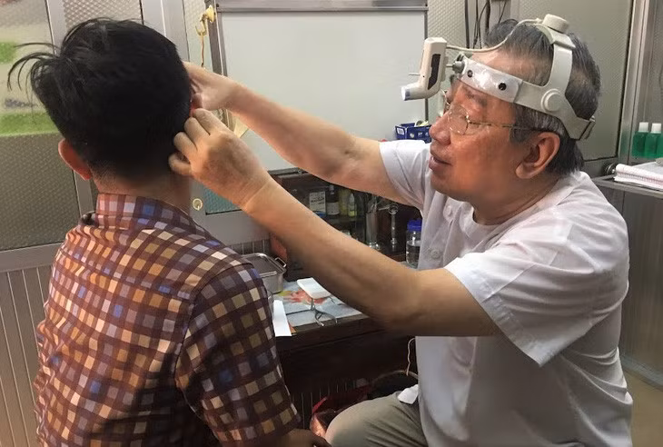 TS.BS Nguyễn Ngọc Minh khám tai cho một bệnh nhân - Ảnh: X.MAI