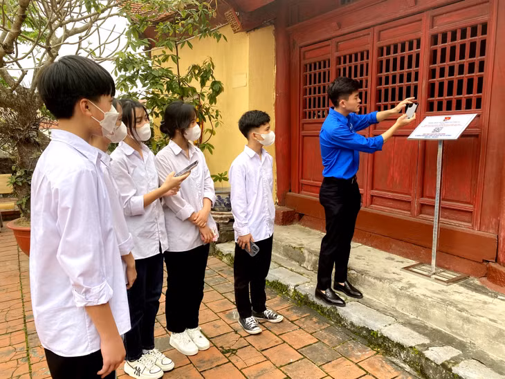 Đoàn Thanh niên xã Cẩm La (TX Quảng Yên) hướng dẫn học sinh quét QR code để tìm hiểu về Miếu Tiên Công.